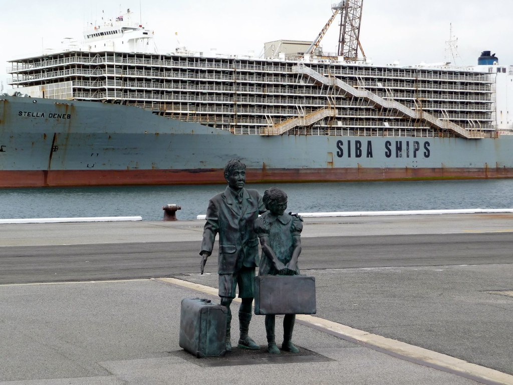 Monumento à emigração japonesa: família de imigrantes com malas em porto, navio ao fundo